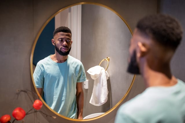 Man looking at himself in the mirror.