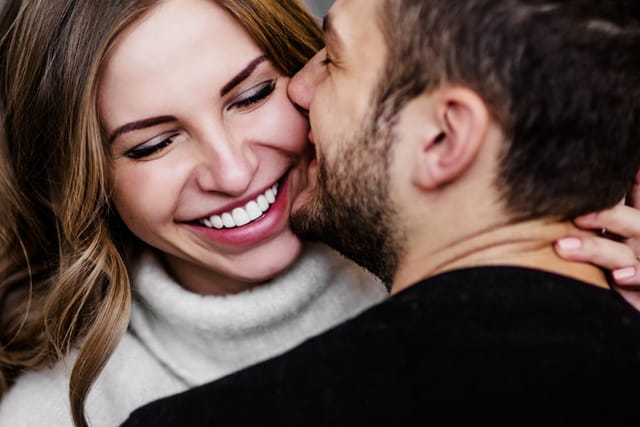 Couple kissing one another.