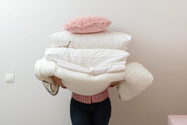 Woman holding a pile of laundry.