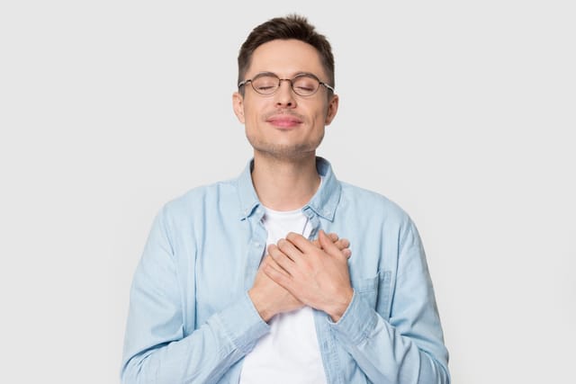 Man holding his hands to his heart.