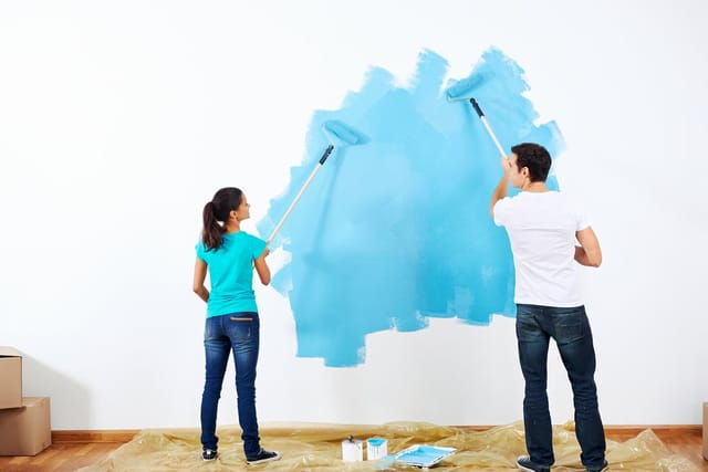 Two people painting walls of home.