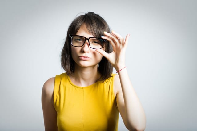 Woman with glasses looking skeptical.