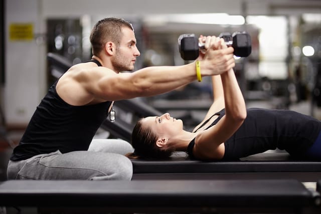 Personal trainer working with a client at the gym.