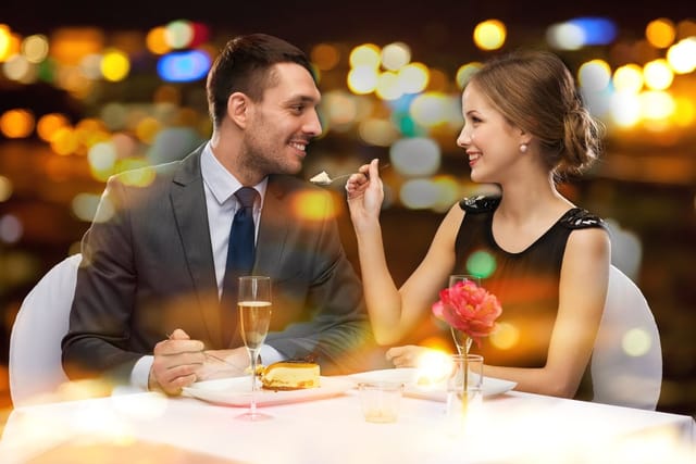 Couple eating at a fancy restaurant on a first date.
