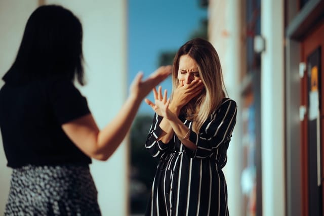 Two women crying and arguing.