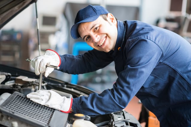 Mechanic checking a car's engine.