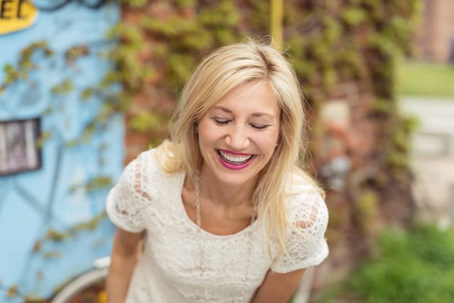 Woman laughing outdoors.