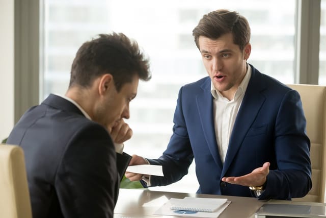 Angry boss with his coworker in the office.