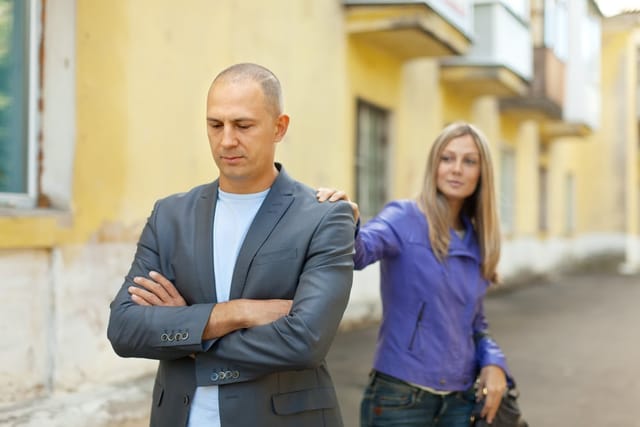 Couple fighting and walking away from one another.
