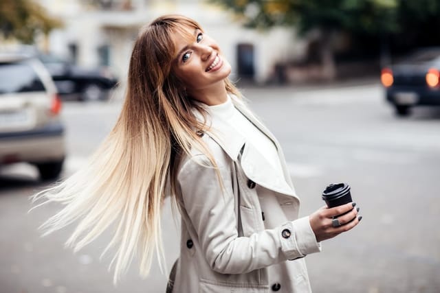 Woman on a walk alone with coffee.