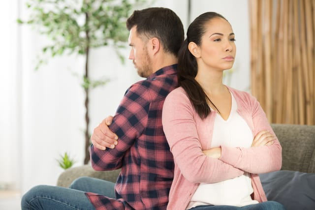 Couple sitting back to back.