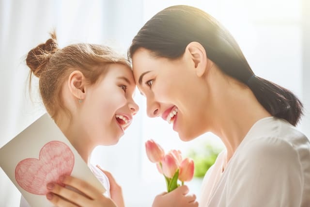 Mother and daughter smiling at one another.