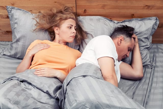 Man and wife laying in bed.