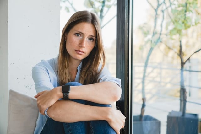 Sad looking woman sitting alone.
