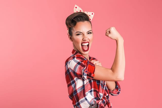 Woman flexing her muscle looking strong.