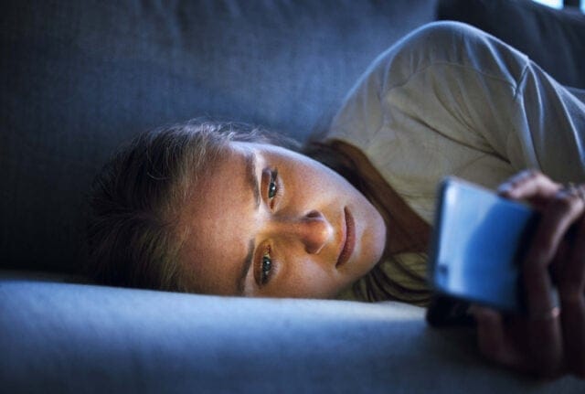 sad woman texting on couch
