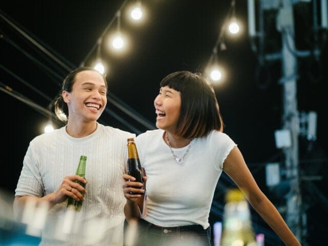 couple laughing with beer at night
