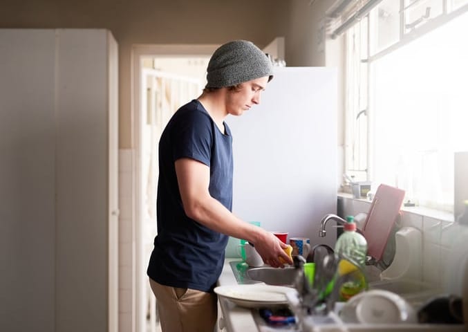 guy washing dishes apartment