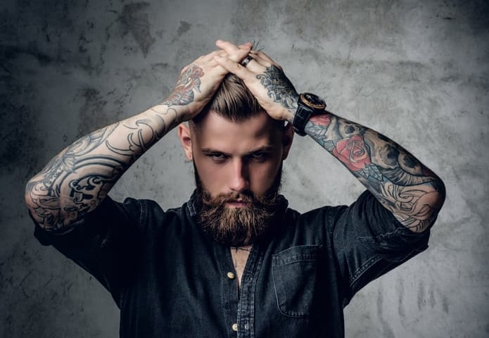 man with tattoos looking serious