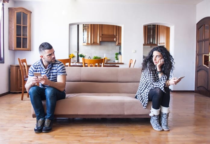 unhappy couple sitting on couch