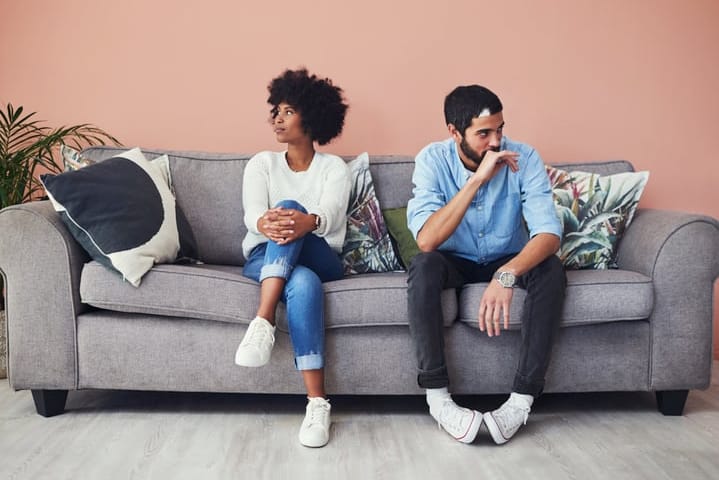 unhappy couple sitting on couch