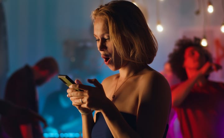 drunk woman texting in a club