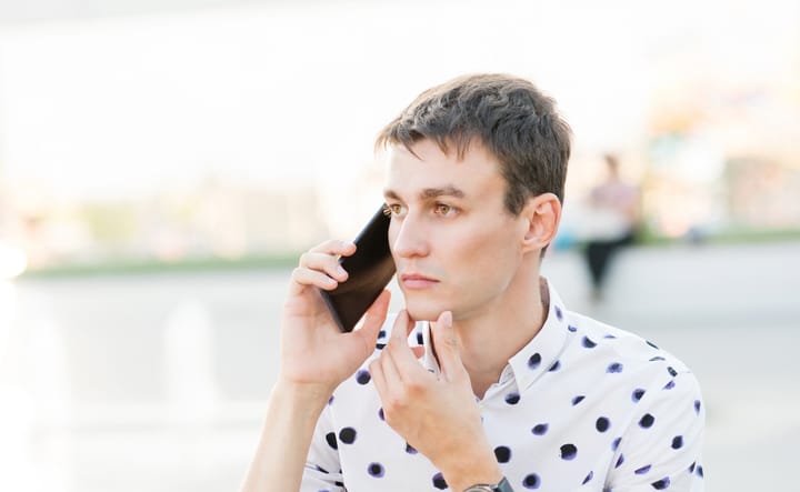 pensive guy on phone outside