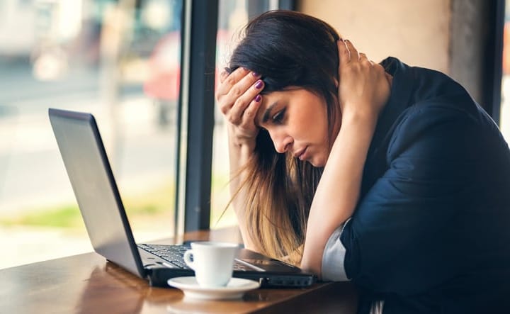 Woman thinking at her computer.