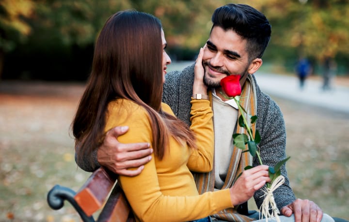 man giving woman a red rose