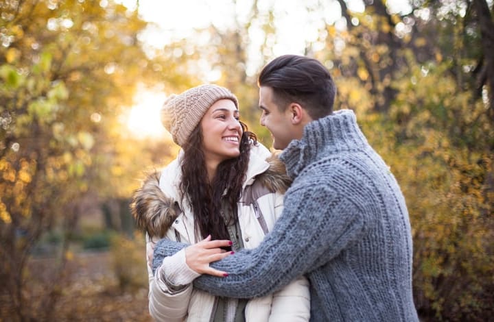 Smiling couple hugging in park