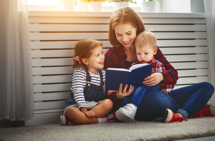 Mother reads book to children son and daughter