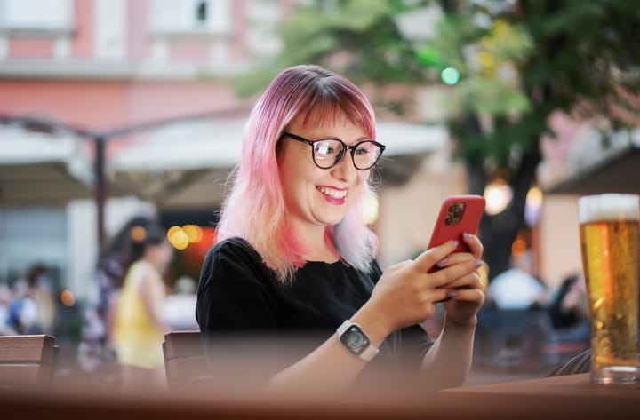 happy woman texting at cafe