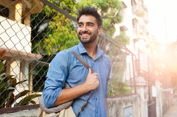 smiling guy walking down street