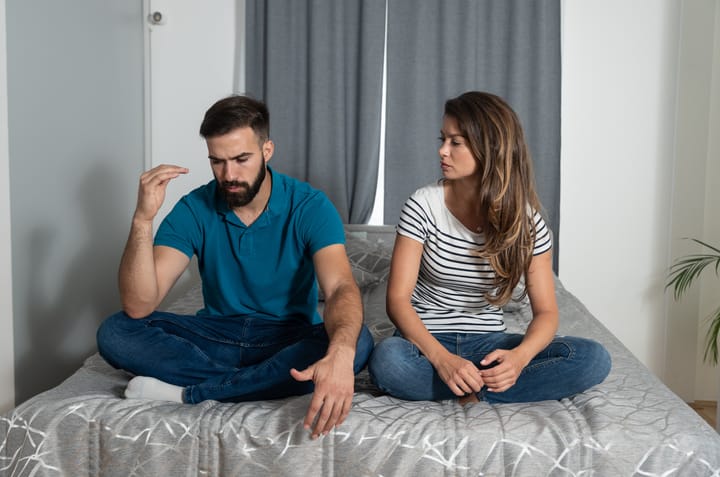 young couple arguing in bed