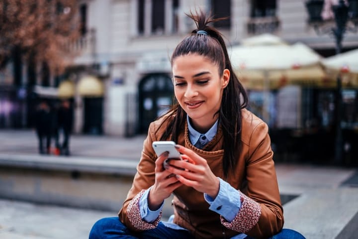 young woman outside texting