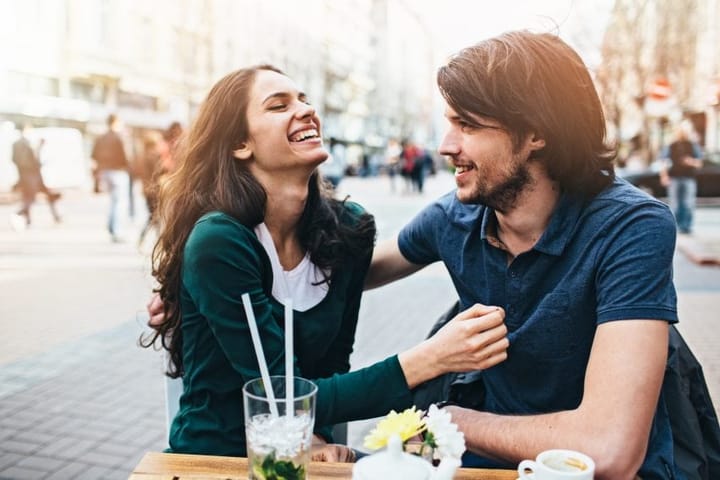 couple flirting and laughing at outdoor cafe