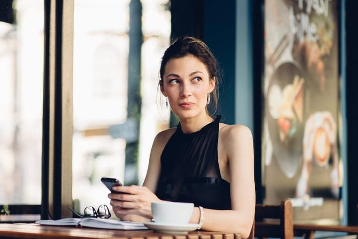 Attractive girl using phone in the cafe
