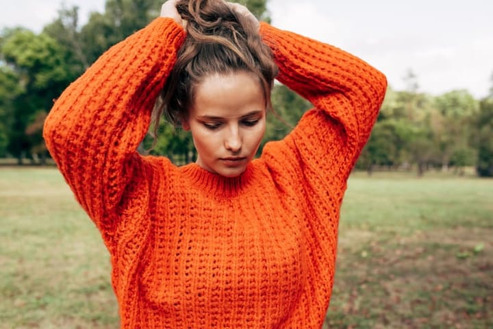 woman orange sweater outdoors