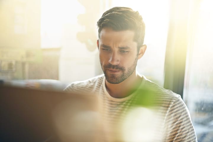 Handsome young man with beard on laptop