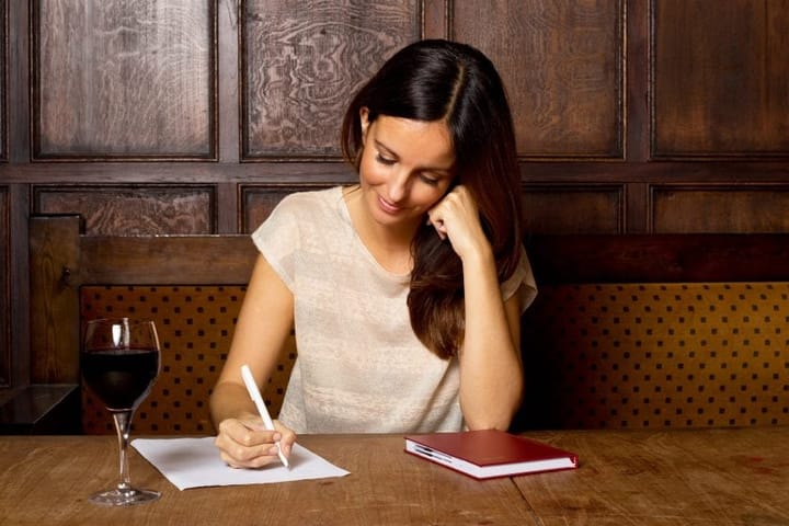 Woman writing list in pub