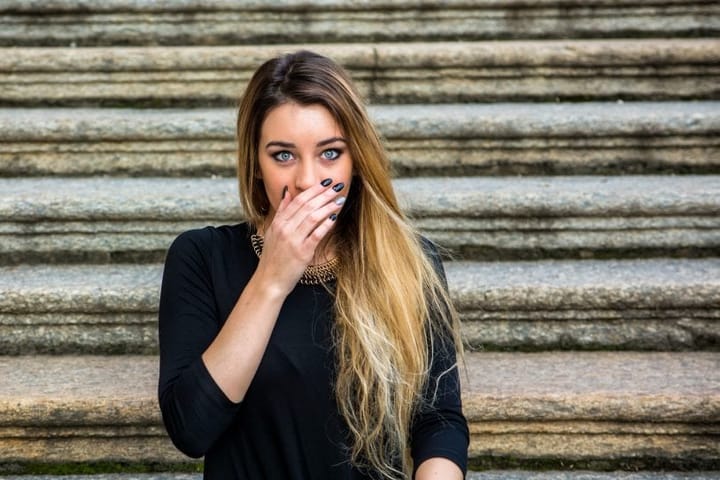 Young woman covering her mouth in shock