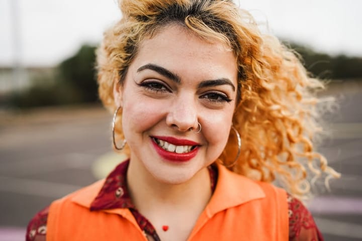 smiling woman in orange shirt