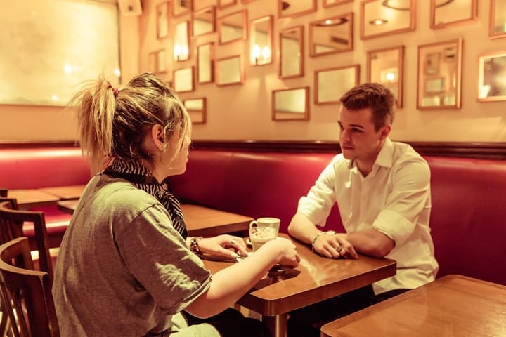 Young Parisian couple having conversation at a Cafe.