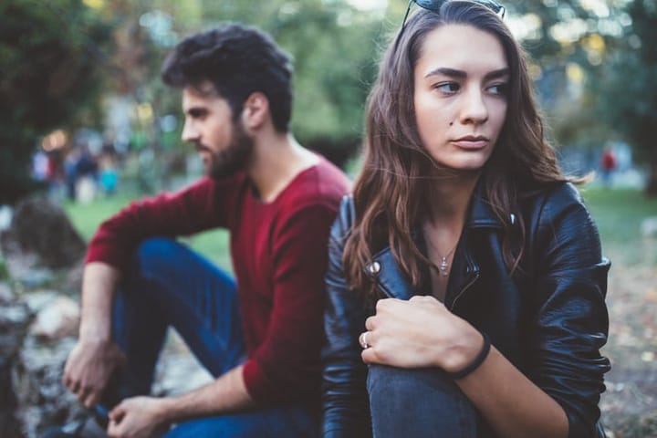 unhappy couple sitting outside