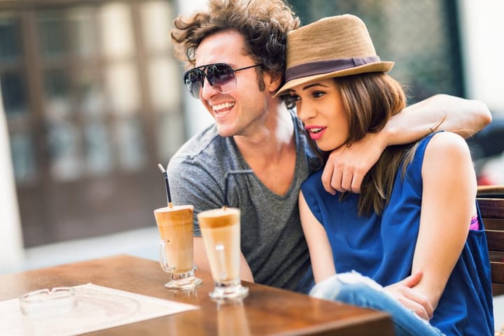 Close up of a happy couple enjoying a sidewalk cafe