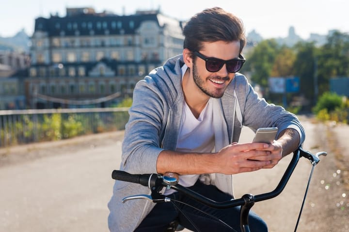 Guy on bike with smartphone