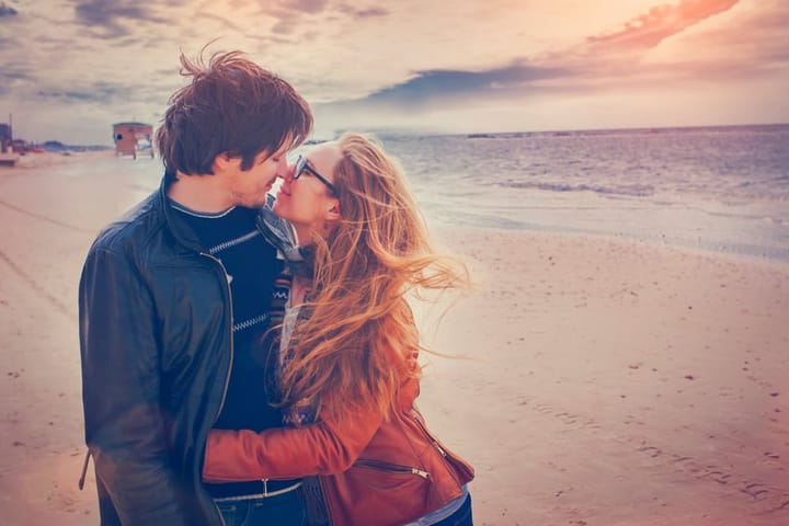couple kissing beach winter