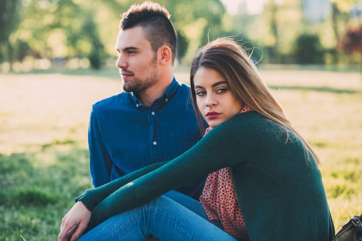 unhappy couple sitting outside