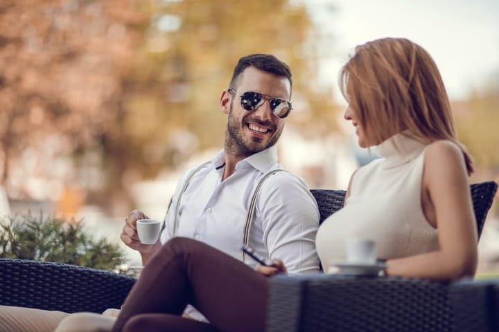 Happy businessman talking to his female colleague in a cafe.