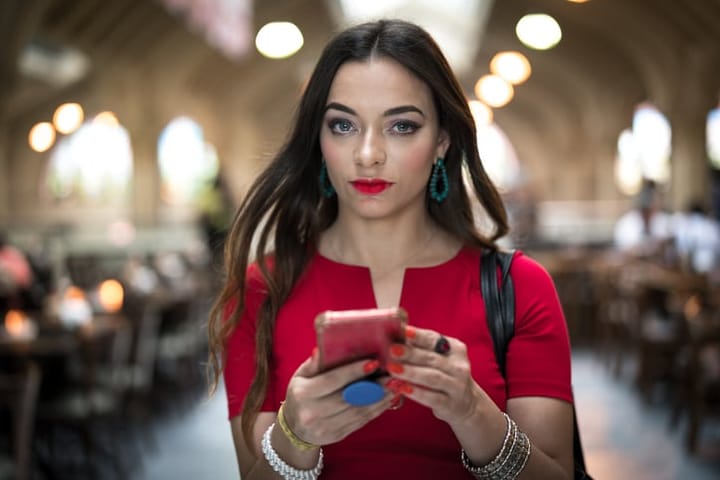 brunette woman in red usingn mobile